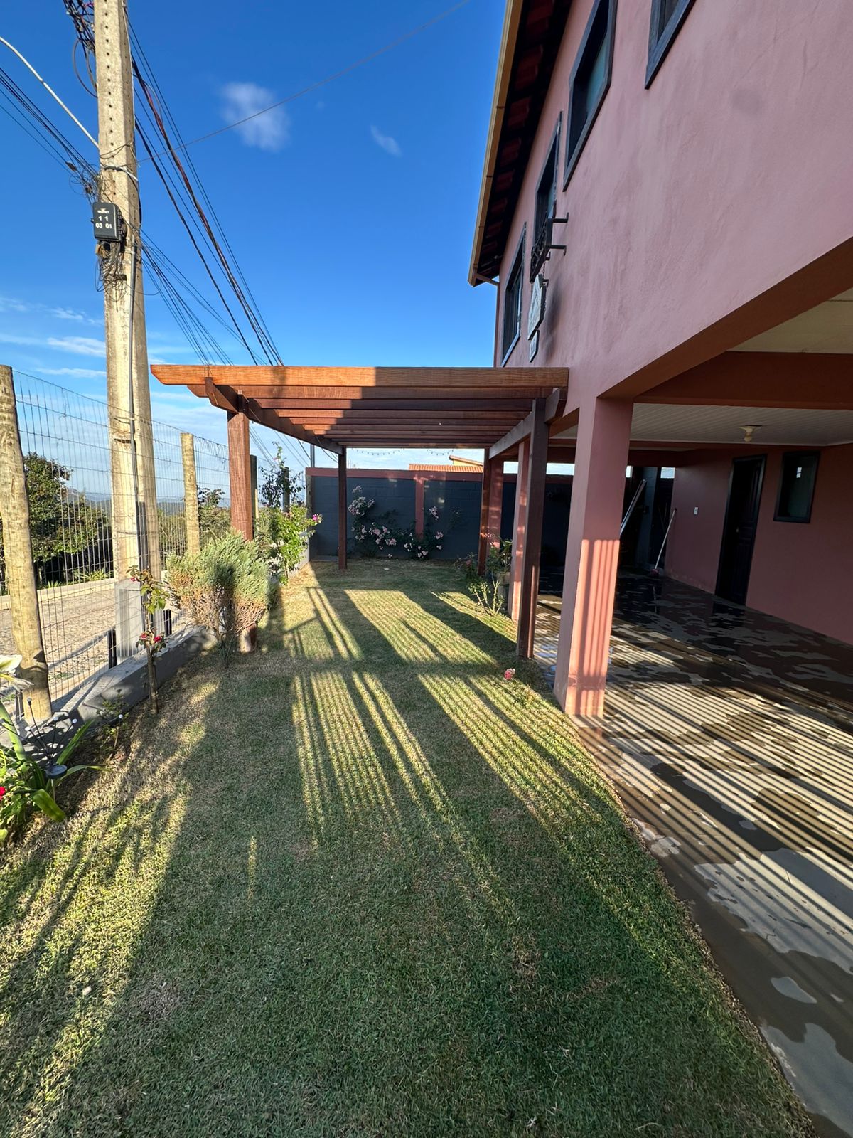 Área com pergolado e jardim